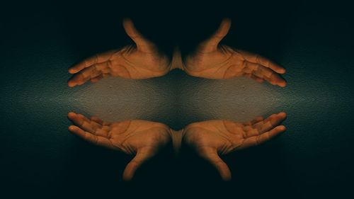 Close-up of human hand against black background