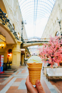 Midsection of person holding ice cream against building