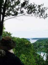 Rear view of man looking at sea against sky