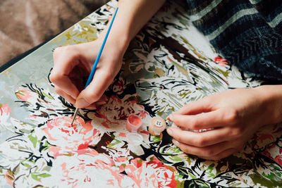 Cropped hands of woman painting