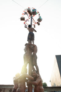 Low angle view of people against clear sky