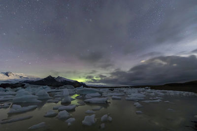 Scenic view of snowcapped mountains against sky at night
