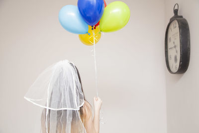 Close-up of bride holding multi colored balloons