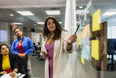 Female business professional doing brainstorming with colleagues at office