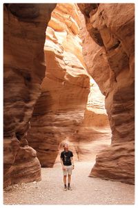 Full length of man standing amidst rock formations