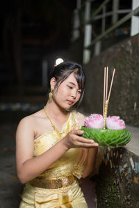 Portrait of young woman holding bouquet