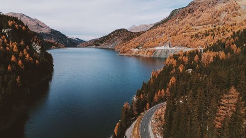 Scenic view of river passing through mountains against sky