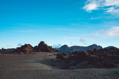 Scenic view of rocky mountains against blue sky