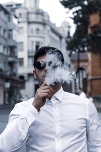 Portrait of man smoking cigarette outdoors