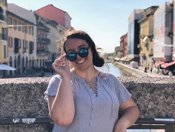 Portrait of young woman wearing sunglasses in city