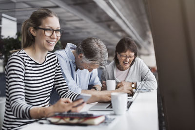 Happy business people sitting at counter in office