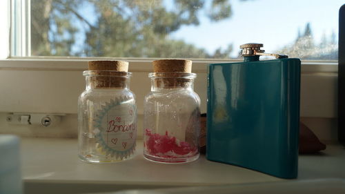 Close-up of bottles on window sill