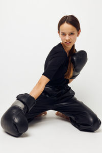 Portrait of young woman exercising against white background