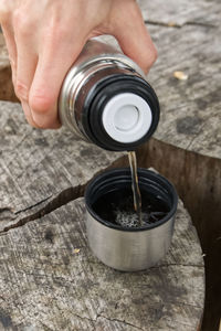 Midsection of person pouring coffee in cup