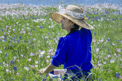 Woman wearing hat while standing in field