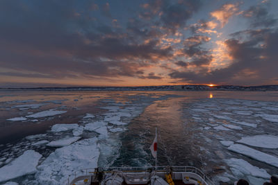 Scenic view of frozen sea against sky during sunset