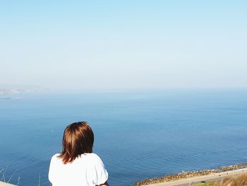 Rear view of woman looking at sea against sky