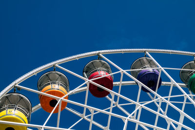 Low angle view of ferris wheel against blue sky