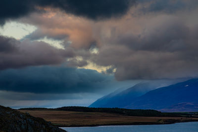 Scenic view of mountains against cloudy sky