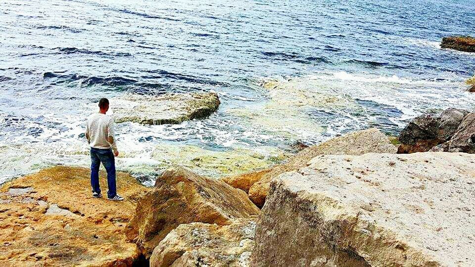 YOUNG WOMAN STANDING ON ROCK