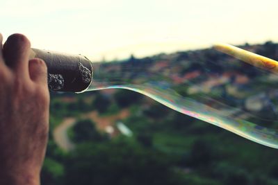 Cropped hand of person blowing bubble