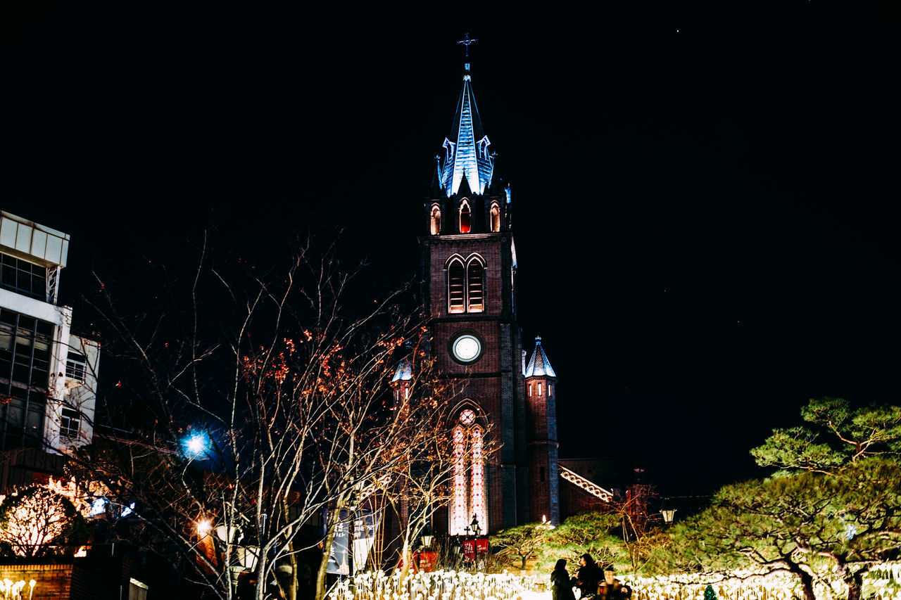 LOW ANGLE VIEW OF ILLUMINATED BUILDING AGAINST SKY AT NIGHT