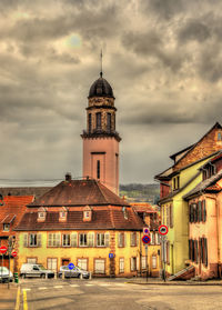 View of buildings in city against cloudy sky
