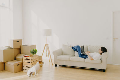 Side view of woman using laptop at new home