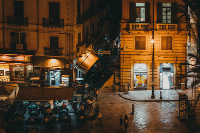 High angle view of illuminated street amidst buildings at night