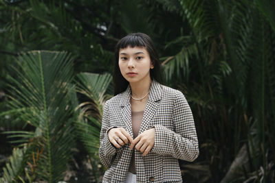 Portrait of woman standing against plants