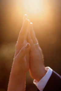 Close-up of man holding hands against blurred background