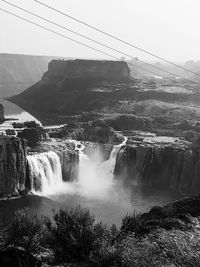 Scenic view of waterfall against sky