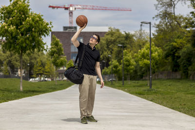 Close-up of mature man throwing basketball while standing outdoors