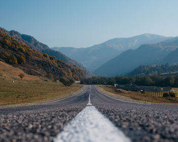 Road leading towards mountains against sky