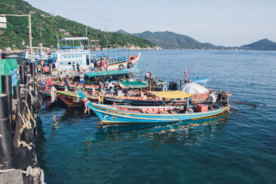 Boats moored in sea against sky