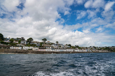 Scenic view of sea by buildings against sky