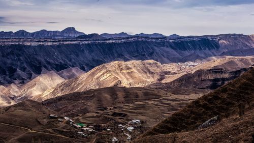 Scenic view of mountain range against cloudy sky