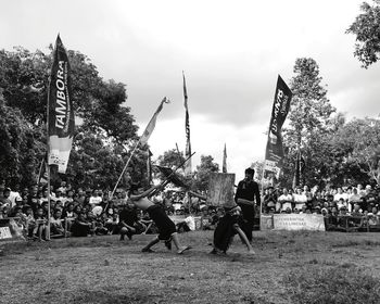 Group of people and plants against sky