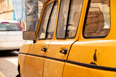 Close-up of yellow car on street