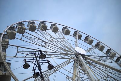 Low angle view of ferris wheel against blue sky