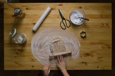 Top view of a young woman making christmas cookies on a wooden table