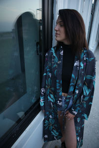 Woman standing by window in bus