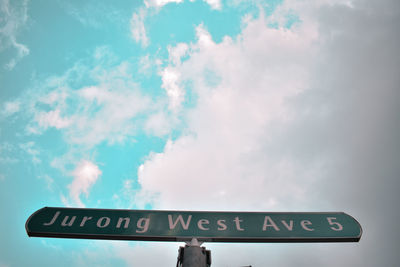 Low angle view of road sign against sky