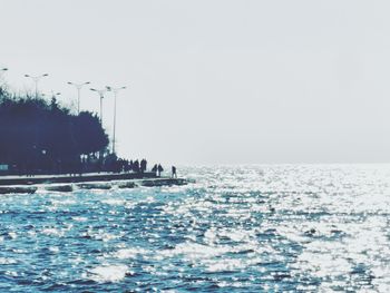 Swimming pool by sea against clear sky