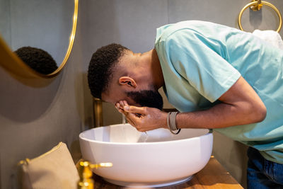 Side view of man washing hands