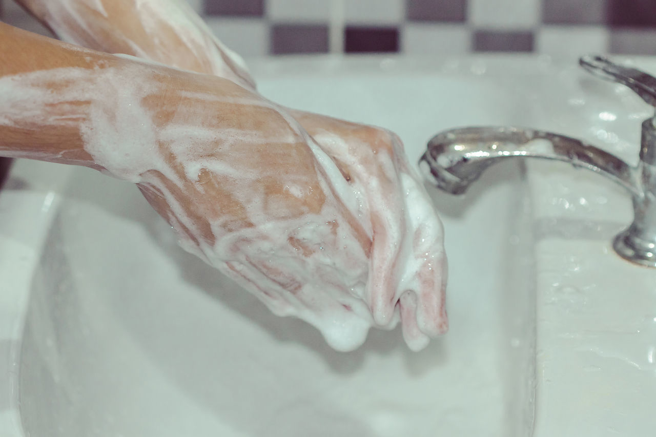 CLOSE-UP OF HAND IN BATHROOM