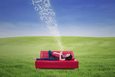 Digital composite image of young woman using phone while lying on sofa