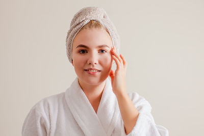 Portrait of smiling young woman against white background