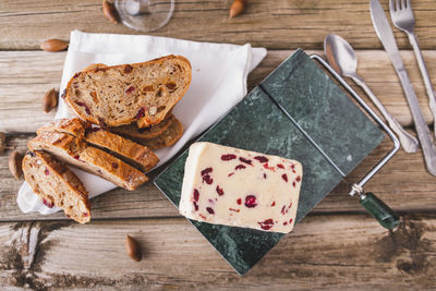 Wensleydale cheese with cranberries on a marble cheese cutting table.