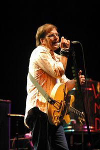 Young man playing guitar at music concert